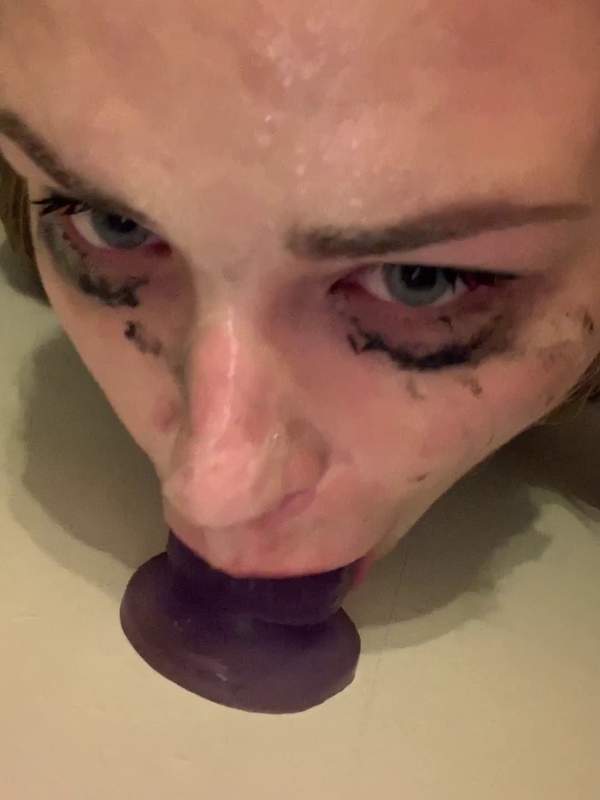 Sie übt Deepthroat mit einem violetten Dildo