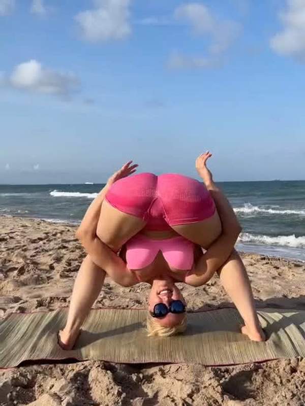 Blonde Frau in Yoga-Hose wird im Strand-Park im Gesicht gesaugt