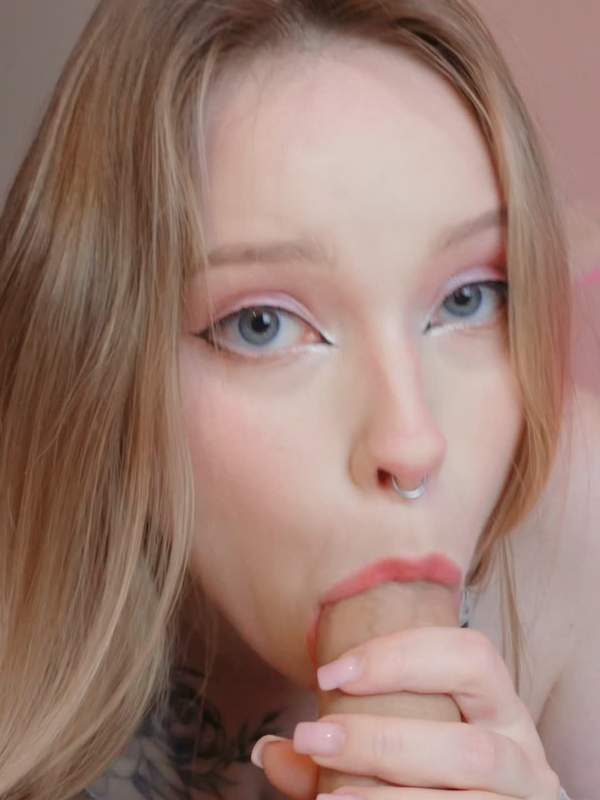 Nette Frau mit Nasenring und Tattoo lutscht