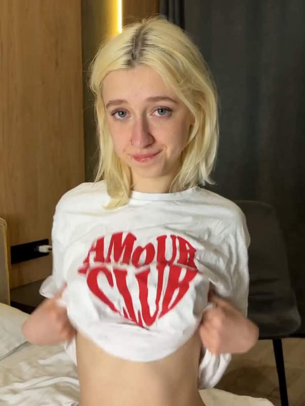 Blondes Mädchen mit Tätowierung und Nippelpiercing zeigt sich solo