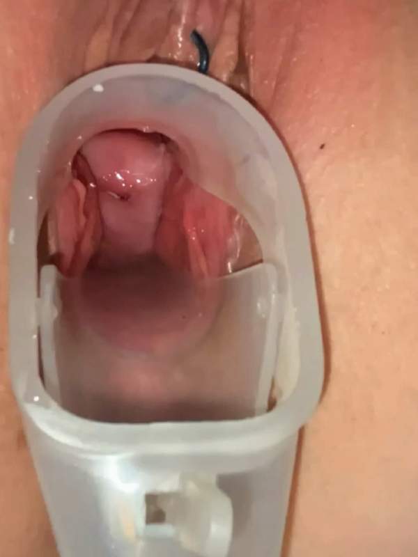 Frau mit Muschelpiercing untersucht ihren Gebärmutterhals