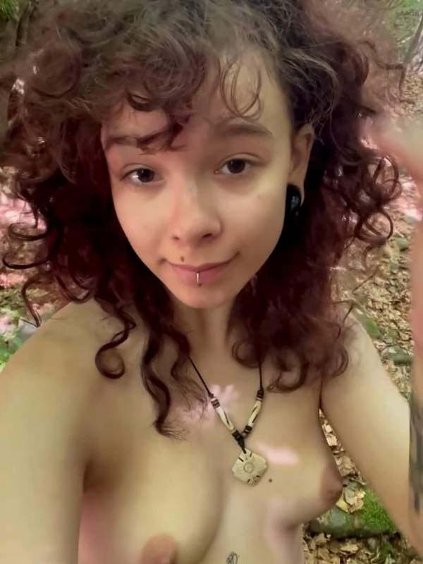 Nackte Frau mit Tätowierung sucht im Wald nach Spaß