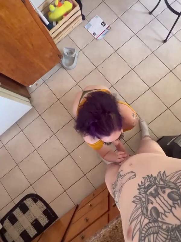E-Girl mit lila Haaren und Tätowierung reitet auf dem Schwanz