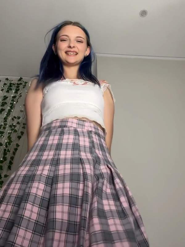 Zierliche Brünette mit blauem Haar und Minirock zeigt sich rasiert und sexy solo.