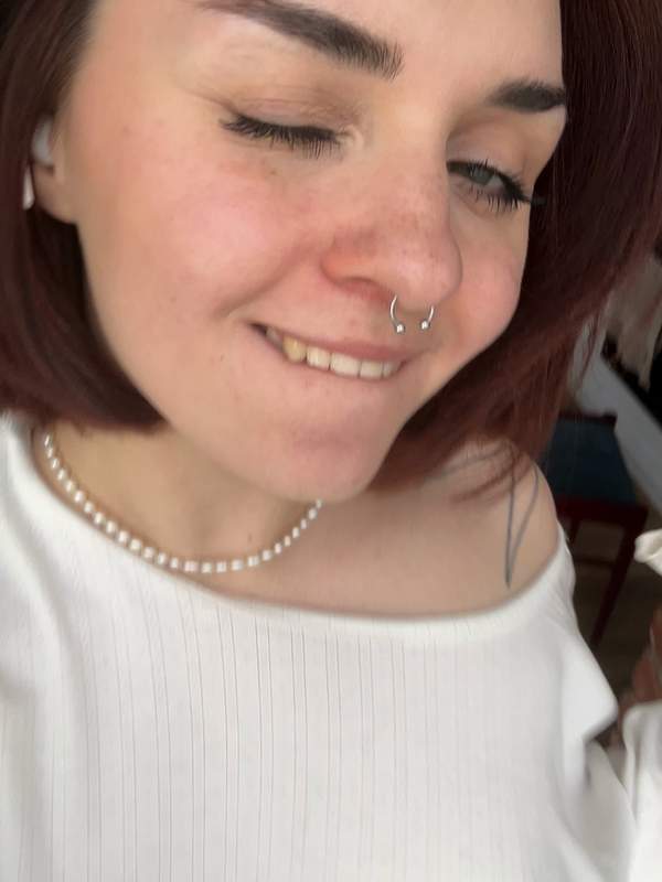 Süßes Mädchen mit Nasenpiercing und Tätowierung zeigt Solo-Szene