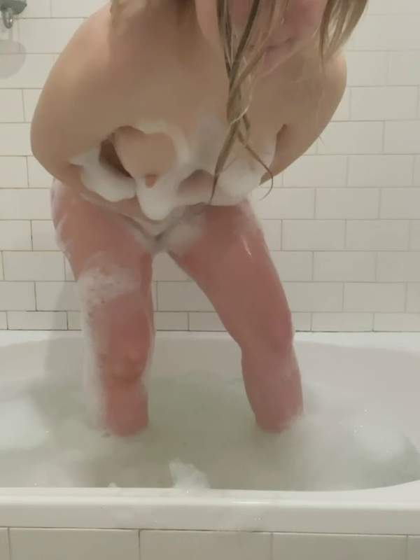 Amateurin reinigt sich im Bad mit Schaum