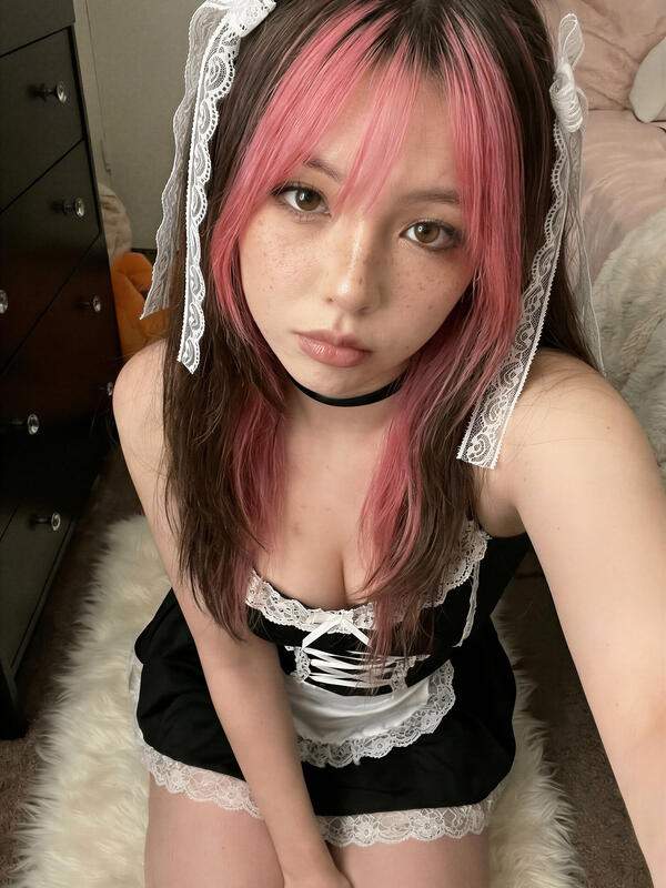 Asiatische Frau in Kostüm und Unterwäsche zeigt Nacktfotos