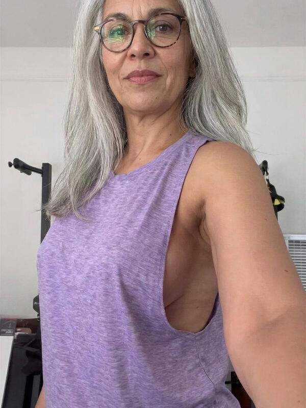 Reife Frau in Leggings und Brille neckt draußen