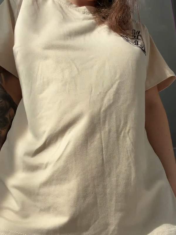 Junge Frau hebt Shirt und zeigt tätowierten Arsch