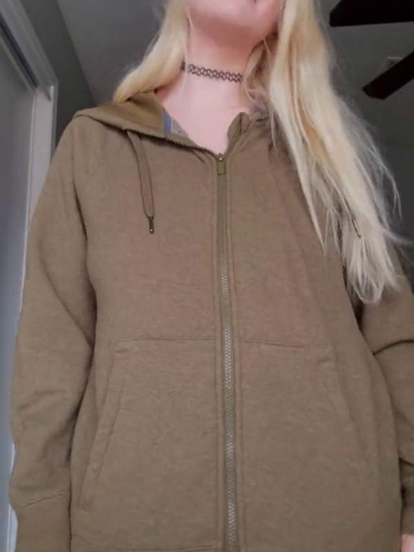 Nahe blonde in grüner Hoodie zeigt nackte Brüste