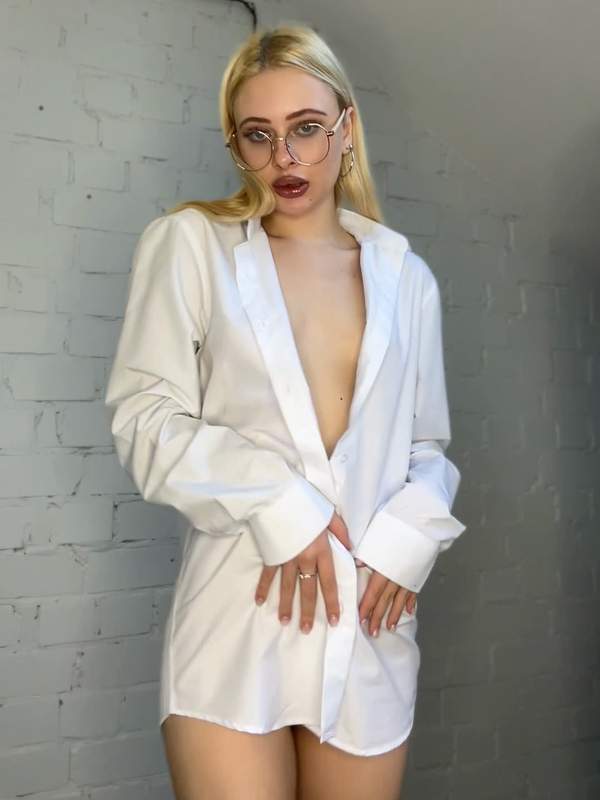 Blondes Mädchen mit Brille zeigt ihre natürlichen Brüste