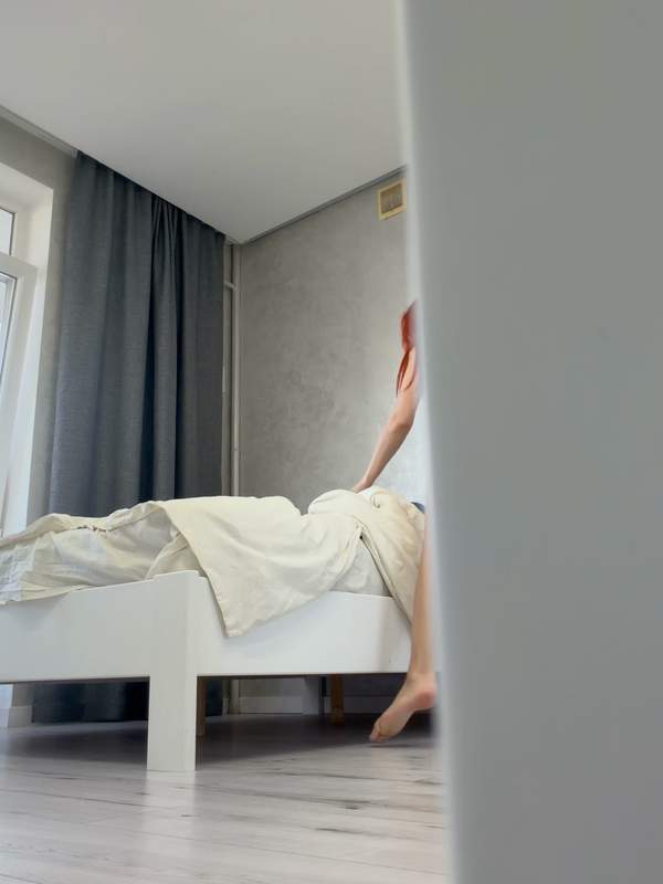 Nackte Rote mit Brille posiert im Bett