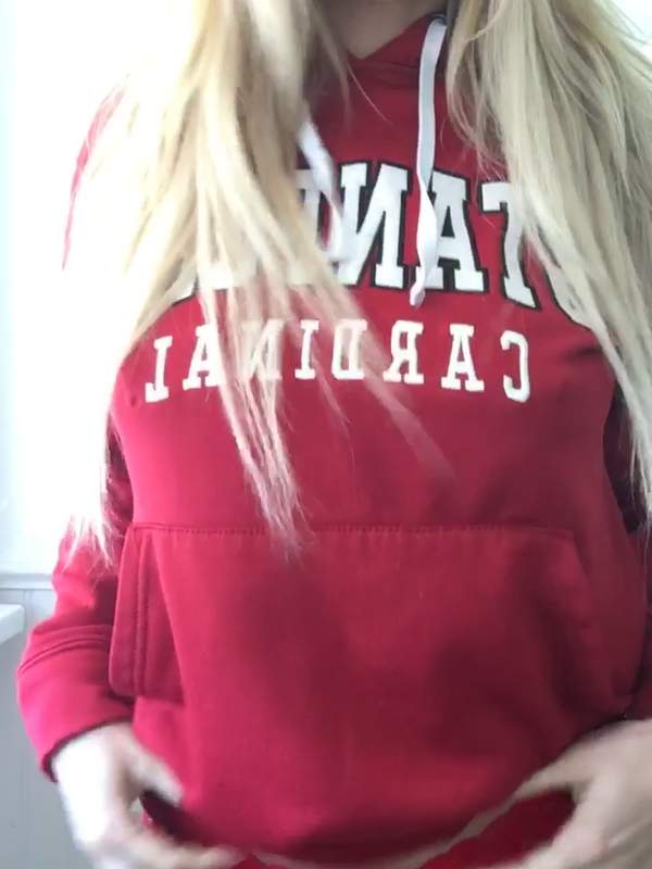 Blonde Frau in roter Kapuzenjacke zeigt ihre Titten