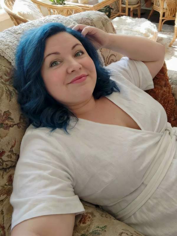 Mollige Frau mit blauen Haaren flirtet im Chat