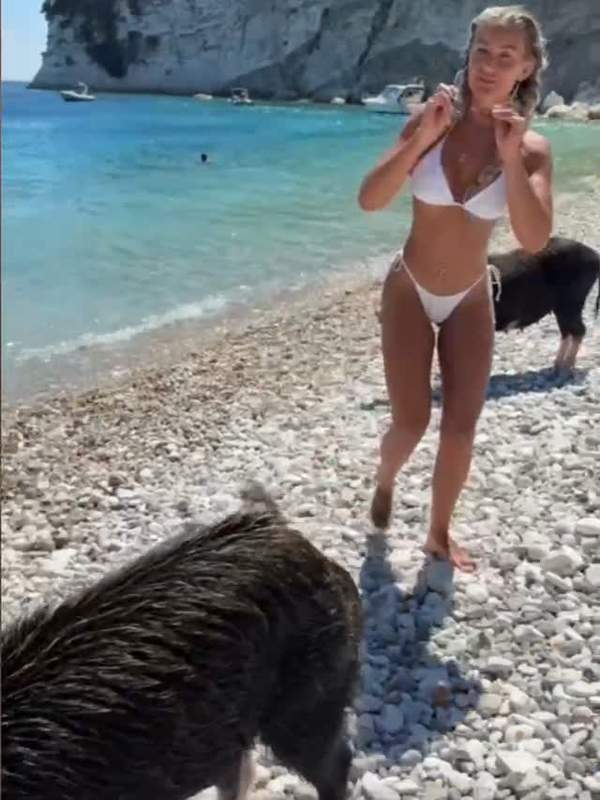 Blondine mit Tattoos lässt nasses Wasser ihre Beine hinablaufen