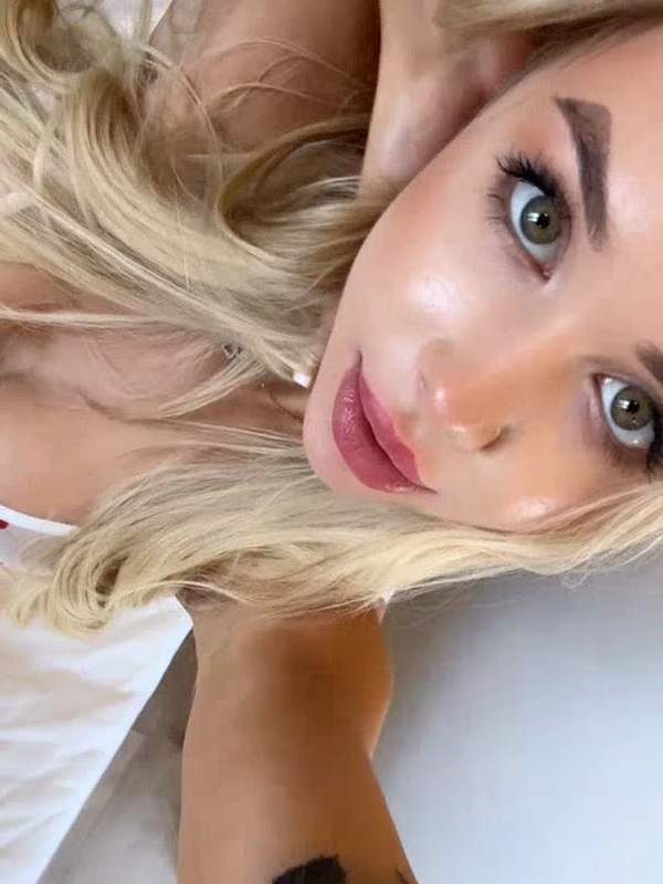 Blondes Mädchen mit Tätowierung zeigt ihre Titten solo
