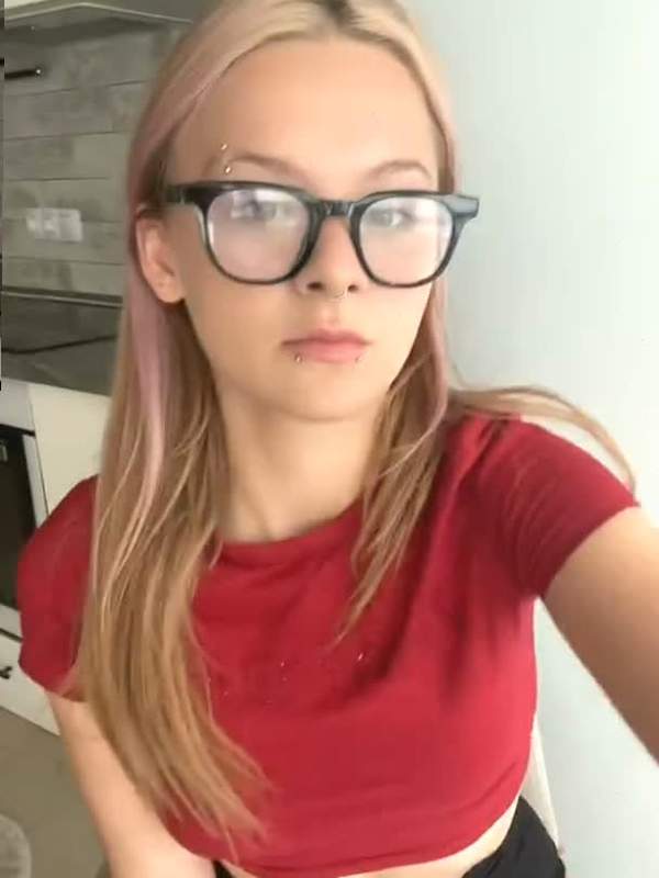 Nette Blondine mit Brille und Piercing neckt im Video
