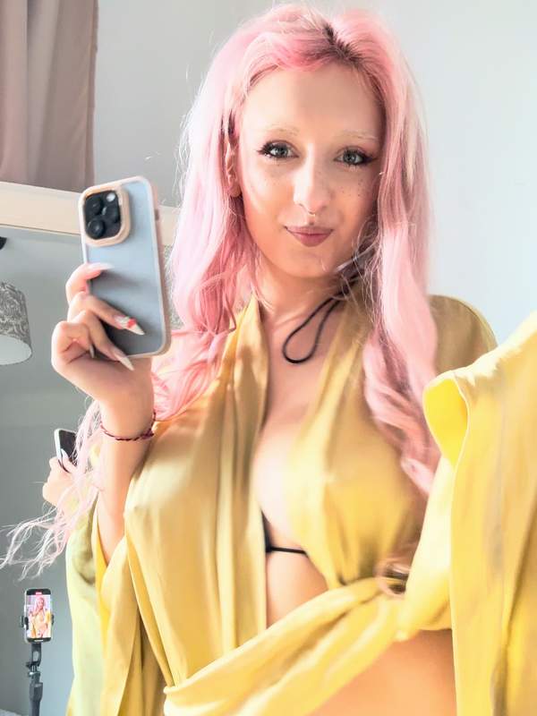 Blondes Mädchen mit bunter Haarpracht und Tätowierung zeigt Solo-Szene