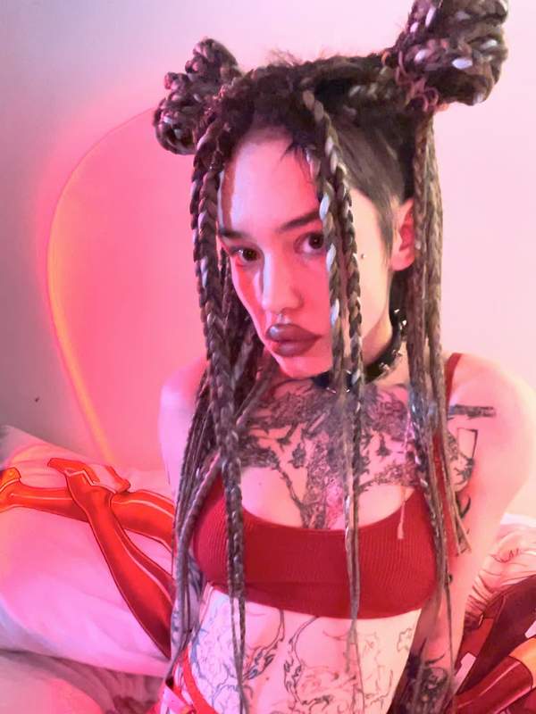 Brünette mit Dreadlocks und Tätowierung zeigt Solo-Szene im Fischernetz