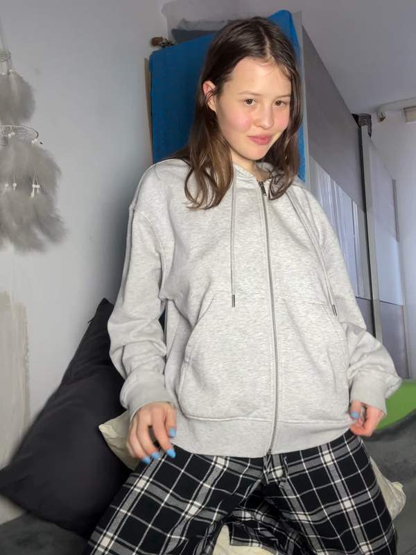 Niedliche Brünette hebt Hoodie und zeigt blinkende Titten