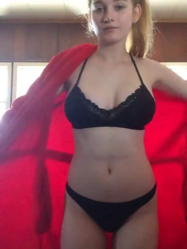 Niedliche Teenie in knappen Bikini vor rotem Hintergrund