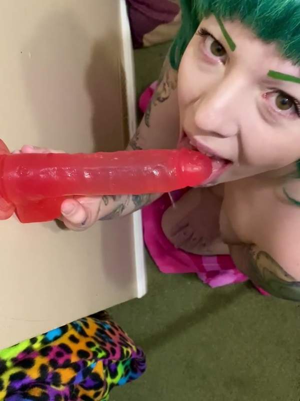 Grüne Frau übt Deepthroat mit rotem Dildo