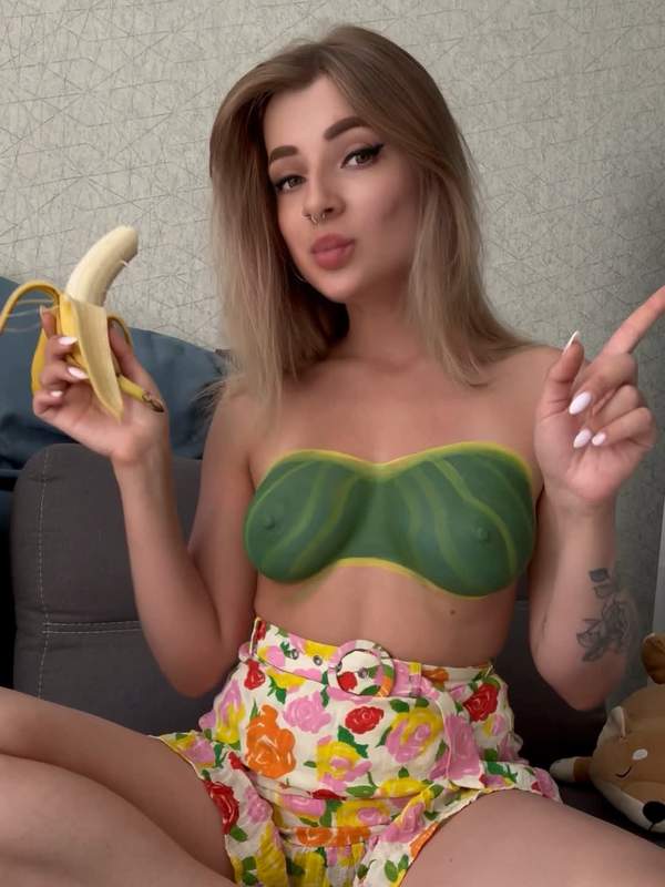Heiße Blondine mit Banane und Tätowierung