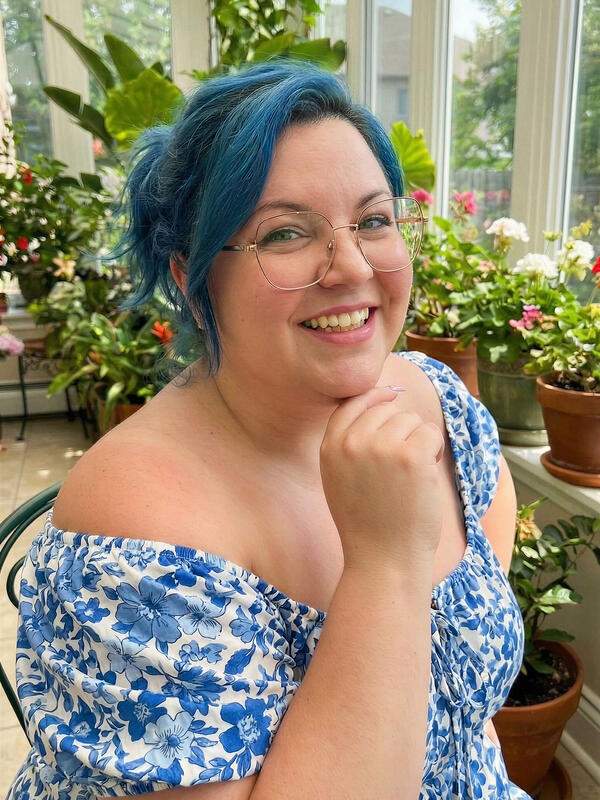 Mollige Frau mit Brille und blauen Haaren zeigt nackte Fotos