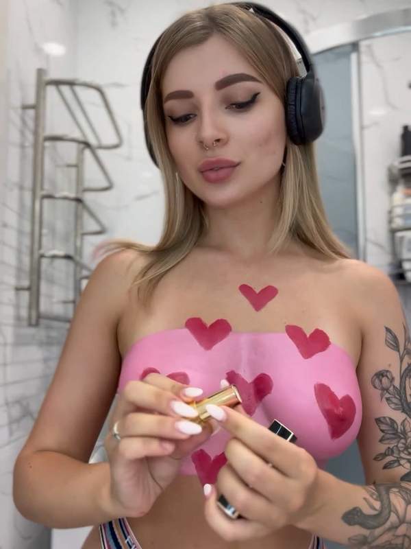 Kleine Blondine bemalt ihre roten Lippen