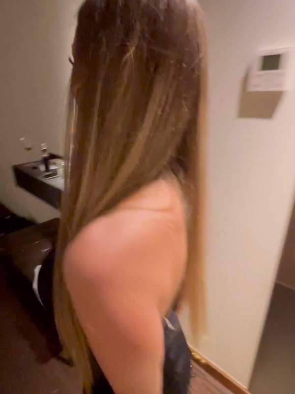 Model zeigt sich in kurzem schwarzen Kleid