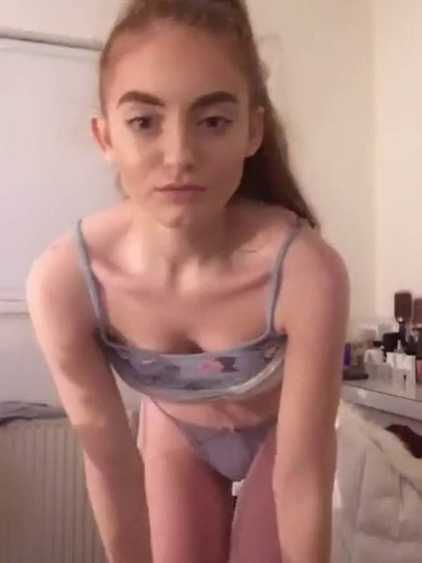 Niedliche Teenie in blauem Bikini auf dem Bett