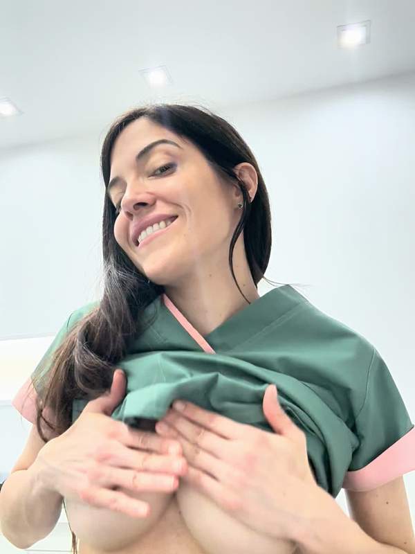 Krankenschwester zeigt Nippel in medizinischer Kleidung