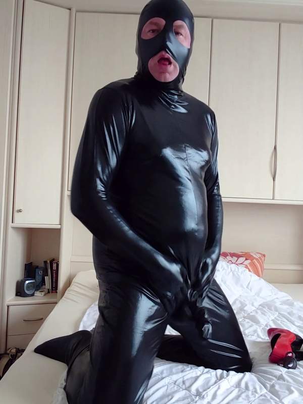 Frau masturbiert in Latexmaske und Absätzen