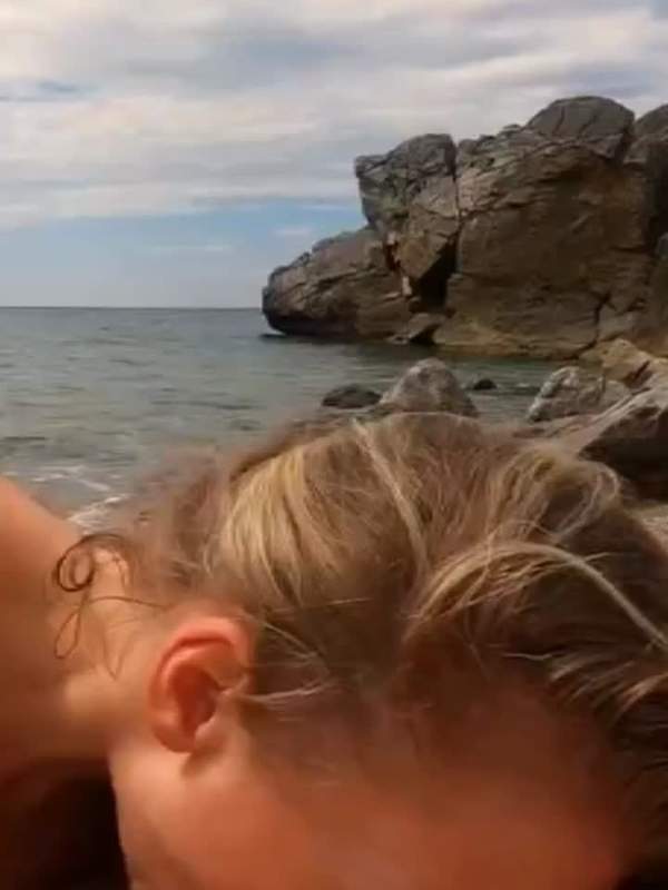 Brünette und Blondine lutschen am Strand