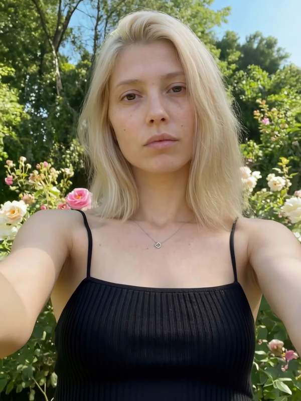 Blonde Frau neckt sich draußen im Chat