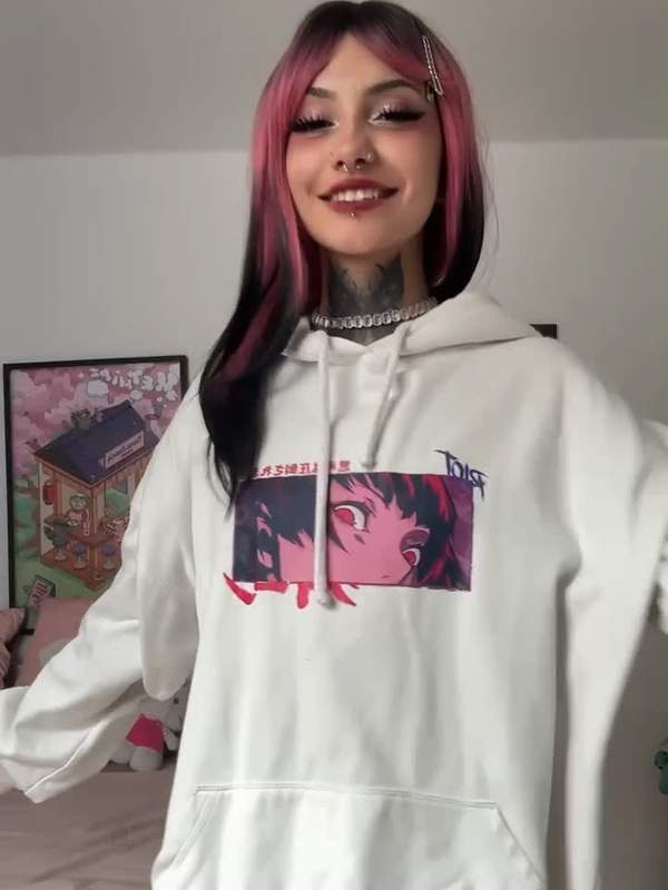 Junge Frau mit bunten Haaren und Piercings zeigt ihre kleinen Titten