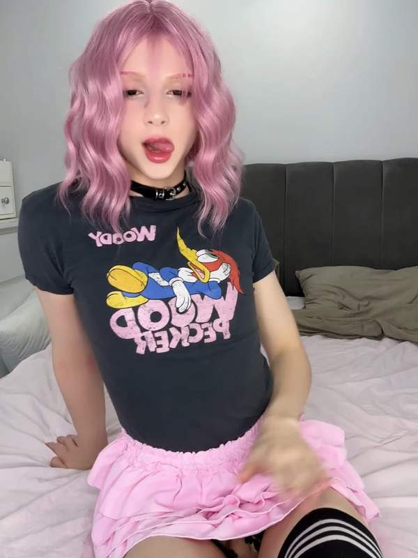 Zierlicher Femboy in rosa Rock und Strümpfen