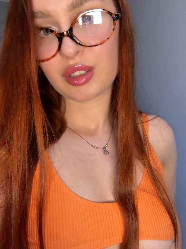 Frau mit Brille zeigt Dildo in Mund