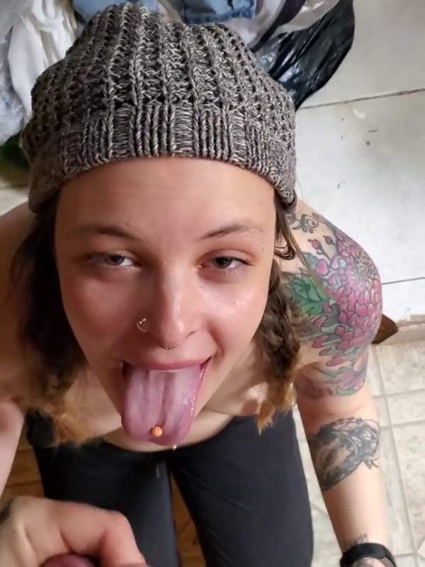 Frau mit Tätowierung und Piercing lutscht hart