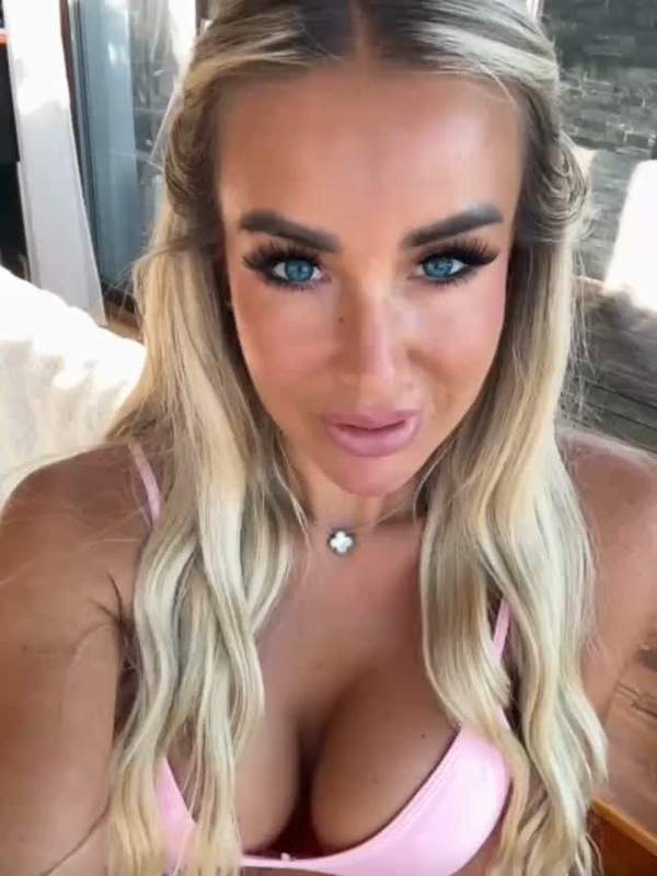 Blonde Frau zeigt ihre Brüste und Klobase