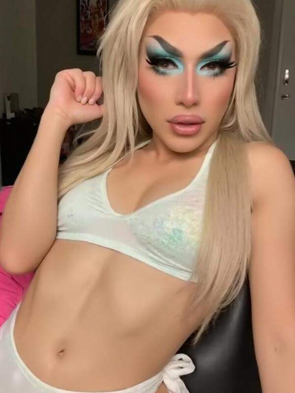 Drag Queen zeigt bunte Haare und künstliche Brüste
