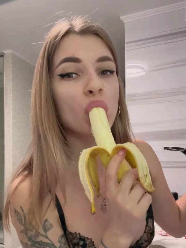 Junges Mädchen in Unterwäsche neckt Banane