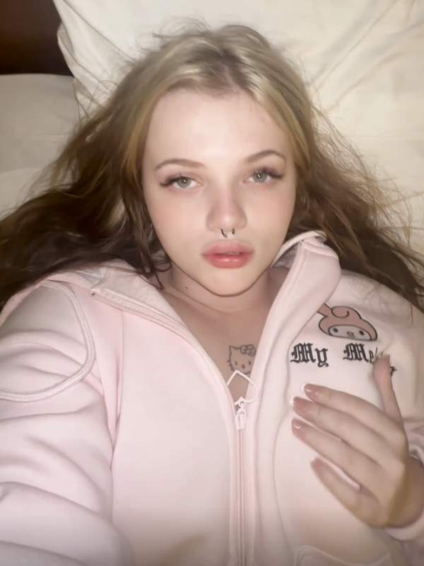 Süßes Mädchen mit Nasenpiercing spritzt im Bett